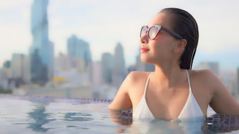 With-the-city-skyline-at-her-back-a-pretty-young-woman-who-has-been-swimming-looks-to-the-open-space-on-her-right
