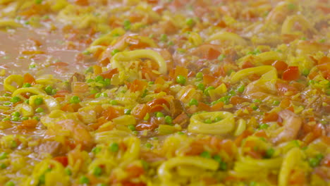 Stirring-in-a-paella-pan-with-lots-of-ingredients-as-shrimps-and-squids