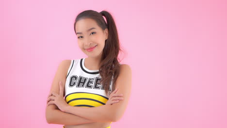 A-medium-close-up-of-a-cute-cheerleader-smiling-with-her-arms-crossed-in-front-of-her