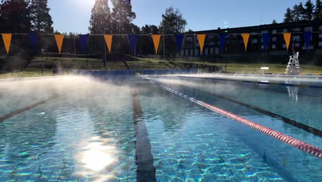 Fog-from-a-warm-swimming-pool-meeting-cold-air-on-a-sunny-autumn-day