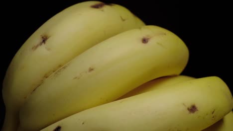 Tilt-Up-Shot-of-Banana-Bunch-on-Black-Background,-Closeup