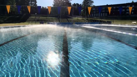 Fog-from-a-warm-swimming-pool-meeting-cold-air-on-a-sunny-autumn-day