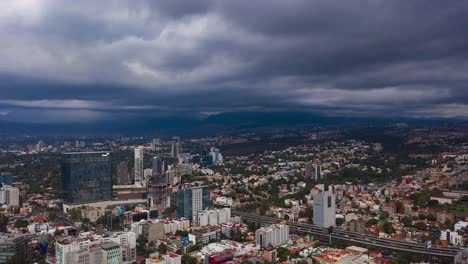 Aerial-dronelapse-view-of-dark,-storm-clouds-moving-over-buildings-and-a-busy-road,-in-Mexico-city,-America---Reverse,-hyper-lapse,-drone-shot