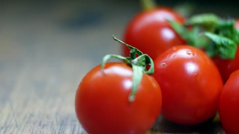 Raw-fresh-tiny-red-juicy-wet-cherry-tomatoes-on-wooden-kitchen-surface-selective-focus-closeup-dolly-right