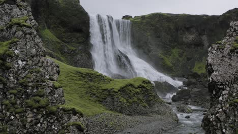Vista-De-La-Majestuosa-Cascada-Fagrifoss-Entre-Las-Rocas-En-El-Sureste-De-Islandia---Toma-Con-Zoom