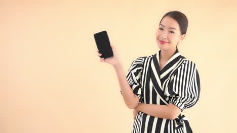 An-attractive,-sassy,-young-woman-dressed-in-a-zebra-print-dress-raises-her-smartphone-and-smiles