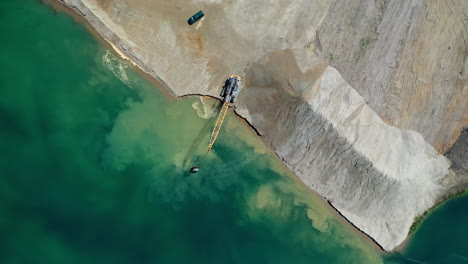 Aerial-top-down-view-of-an-excavator-moving-crushed-stone-into-the-water-in-Hungary