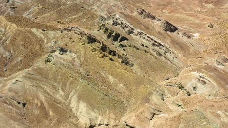 Fliegen-Sie-über-Die-Alten-Geschichteten-Bergformationen-Im-Regenbogenbecken-Der-Mojave-Wüste
