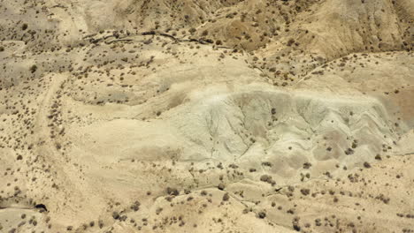 Vista-De-Drones-Volando-Sobre-Las-Montañas-De-Arena-Seca-En-La-Cuenca-Del-Arco-Iris-Parte-Del-Desierto-De-Mojave