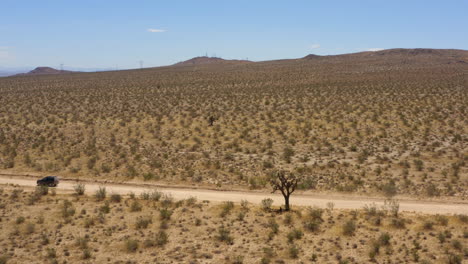 Gran-Suv-Negro-Conduce-Rápidamente-Por-Un-Camino-De-Tierra-En-El-Desierto-De-Mojave-Y-Pasa-Por-Otros-Dos-Caminos-De-Tierra