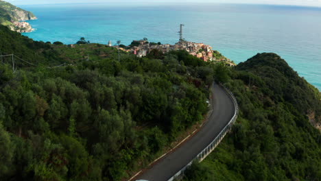 Aerial-view-as-Car-drives-ocean-road-towards-Corniglia,-Italy