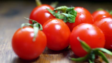 Tomates-Cherry-Mojados-Jugosos-Rojos-Diminutos-Frescos-Crudos-En-La-Superficie-De-La-Cocina-De-Madera-Enfoque-Selectivo-Dolly-Right-Closeup