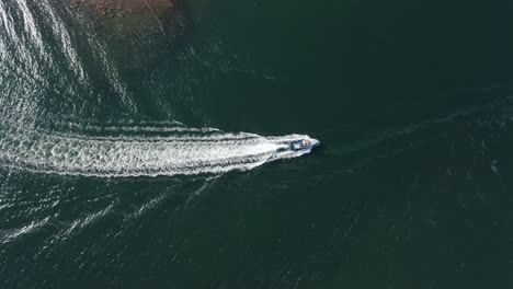 Aerial-view-of-boat-coming-into-a-harbour-at-Inishgort,-Clew-Bay,-on-the-west-coast-of-Ireland