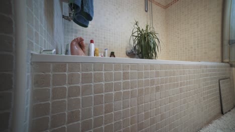 Bathing-with-a-hanging-plant,-relaxing,-propping-feet-in-a-warm-home-bathtub,-wide-angle