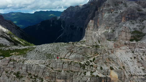 Man-trekking-through-Italian-Dolomites-standing-on-rocky-path