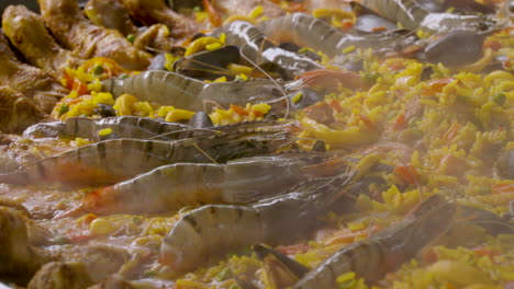 Close-up-shot-of-the-tiger-shrimps-on-a-big-paella-plate-with-lots-of-calamari-and-chicken-legs