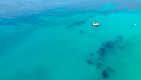 Anchored-boats-on-shallow-lagoon-with-calm-clear-water-of-blue-azure-Mediterranean-sea