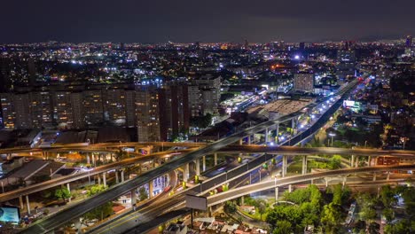 Aerial-drone-lapse-view-over-the-San-Antonio-freeway-and-the-cityscape,-during-night-time,-in-Mexico-city,-America---Reverse,-hyperlapse-shot