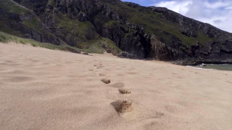 Fußspuren-Im-Sand-Der-Wunderschönen-Höhlenstrandinsel-In-Donegal,-Irland-–-Bodennahe-Dolly-Aufnahme