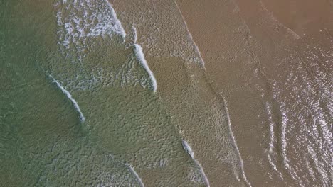 small-waves-slowly-break-on-a-beach-aerial-view