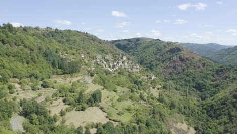 La-Vinzelle,-Französischer-Malerischer-Berg-üppige-Grüne-Landschaft-Dorf-Luftaufnahme-Steigender-Dolly-Links