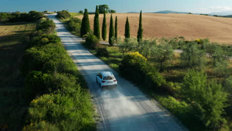 Aerial-shot-of-Car-driving-in-San-Quirico-d'Orcia-of-Tuscany