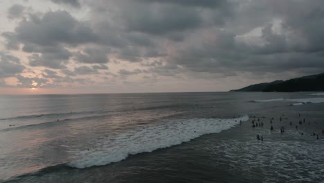 Drone-aerial-shot-panning-revealing-mountains-and-the-people-at-the-beach-in-4k,-Costa-Rica
