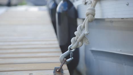 Floating-Boat-Rope-Attached-To-The-Steel-Hook-Rigid-On-A-Wooden-Dock