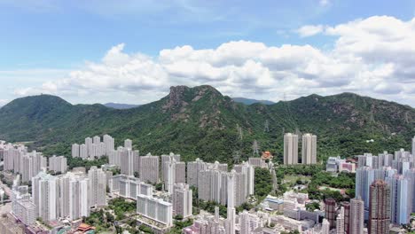 Mega-Wohngebäude-In-Der-Innenstadt-Von-Hongkong-Und-Lion-Rock-Mountain-Ridge-Im-Hintergrund,-Luftbild