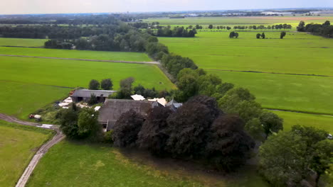 Aerial-of-lush-green-meadows-and-luxurious-farmhouse-in-Holland