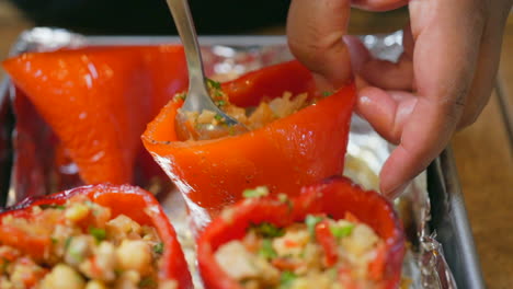 Isolated-macro-view-of-stuffing-red-sweet-bell-peppers-with-a-savory-vegan-mixture---slow-motion