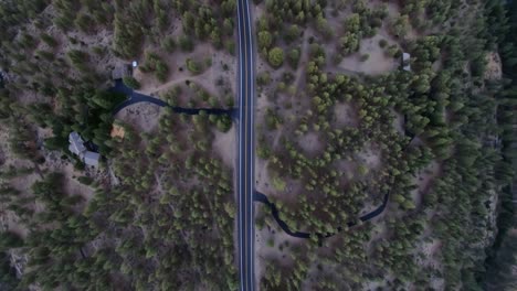 Ariel-view-of-a-single-highway-road-surrounded-by-mountain-trees