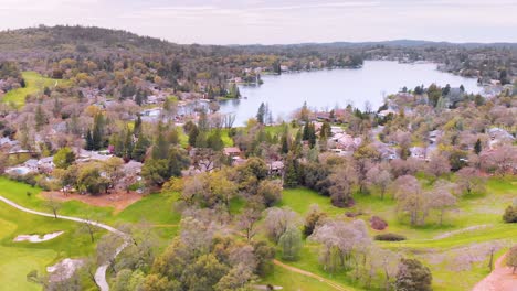Lake-of-the-Pines-Luxury-Golf-Neighborhood-in-Auburn,-California---Surrounded-by-Beautiful-Green-Pine-and-Assorted-Trees,-Vivid-Bright-Green-Golf-Course-and-Nature---Drone-Flying-Up-For-The-Best-View