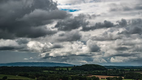 A-time-lapse-of-clouds-on-a-windy-day-looking-over-the-countryside-towards-Bredon-Hill-in-the-Cotswolds,-UK
