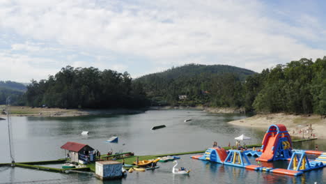 Menschen-Genießen-Wasseraktivitäten-Im-Teleski-Wasserpark-Auf-Der-Insel-Ermal,-Vieira-Do-Minho,-Portugal-–-Aufsteigende-Drohnenaufnahme