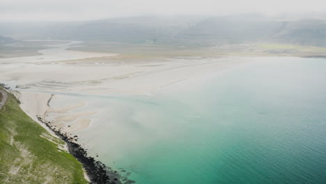 La-Costa-Brumosa-Y-Vasta-De-Islandia-Con-Mar-Azul,-Disparo-De-Drones