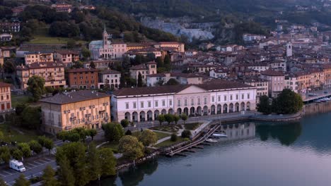 Vista-De-Drones-Del-Lago-Iseo-Al-Amanecer,-A-La-Izquierda-La-Ciudad-De-Lovere-Que-Corre-A-Lo-Largo-Del-Lago,-Bergamo-Italia