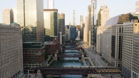Drone-Flies-Backwards-as-Train-Crosses-Bridge-over-River-in-Downtown-Chicago-Loop