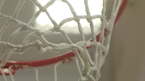 Close-Up,-Rack-Focus-of-New-Basketball-Net-and-Rim-in-an-Empty-Gym