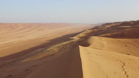 One-man-jumping-on-immense-desert-sand-dunes