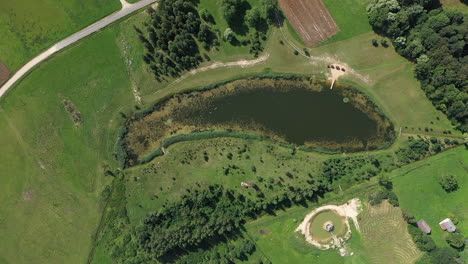 AERIAL:-Ascending-Wide-Shot-of-Uncommon-Pond-That-Looks-Like-Fish