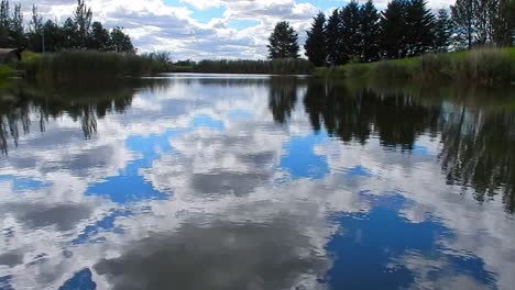 Blue-lake-water-mirror-reflection-tranquillity-bright-scenic-cloudy-sky