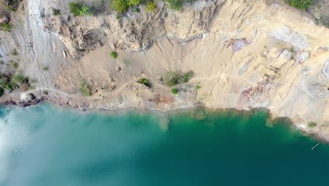 Reveal-shot-of-a-beautiful-blue-lake-with-yellow-sandbank