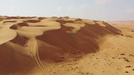 Arid-desert-sand-dunes-on-sunny-day,-Oman
