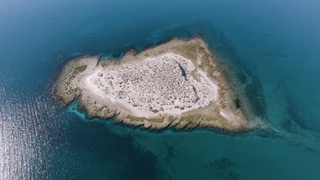 Isla-Desierta-Aislada-En-Medio-De-Un-Mar-Azul-Tranquilo-A-Través-De-La-Mañana-Del-Sol
