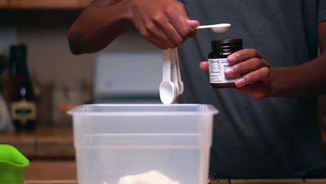 Measuring-yeast-with-a-teaspoon-to-add-to-flour-to-make-batter-or-dough