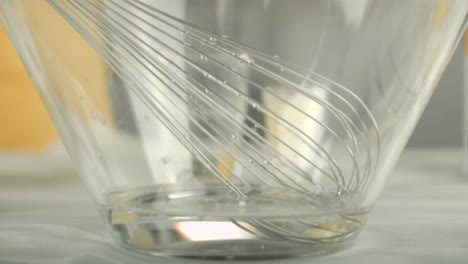Der-Koch-Gibt-Wasser-Und-Veganes-Ei-Ergänzungspulver-In-Eine-Glasschüssel-Und-Beginnt-Zu-Verquirlen