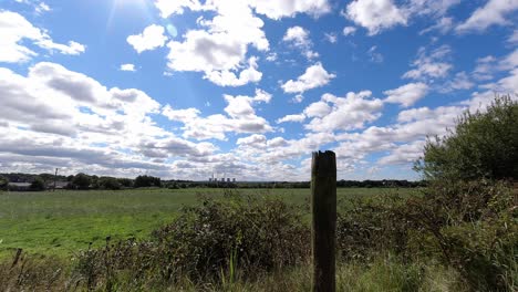 Countryside-farmland-timelapse-meadow-with-fast-moving-clouds-casting-shadows-on-ground-on-sunny-day-dolly-right