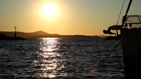 Boats-and-yachts-enter-and-exit-marina-at-sunset-in-Biograd-in-Croatia-in-slow-motion
