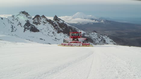 Mountain-snow-groomer-drives-downhill-leaving-corduroy-flat-surface,-Mt-Ruapehu